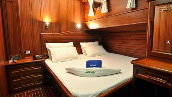 Comfortable double cabin with wooden decor on Gulet Mikado, perfect for restful nights.