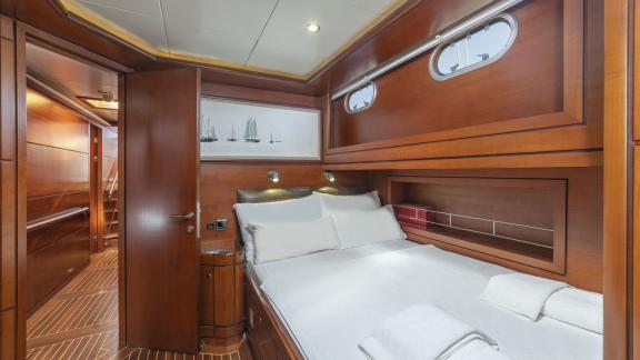 Cosy cabin with double bed and wood panelling on a luxurious sailing yacht.