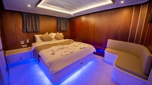 Elegant cabin of the Gulet Buse with 5 cabins, equipped with a comfortable bed and stylish lighting.