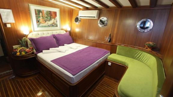 Cosy cabin on the Gulet Prenses Lila with a double bed, purple pillows and blanket