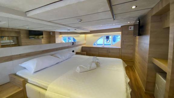 Master cabin of motor yacht Serpil D features a large bed and modern design.