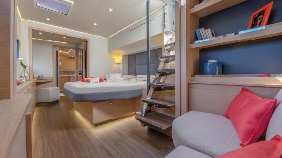 Spacious master bedroom on the Serenissima catamaran with sofa and ample space.