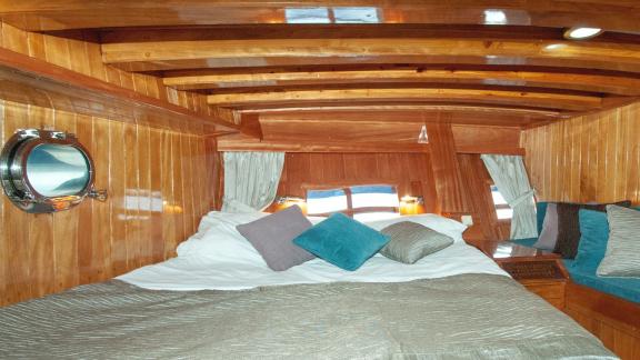 Large bed and cozy decor in the sleeping cabin of Gulet Nikola. Ideal for restful sleep.