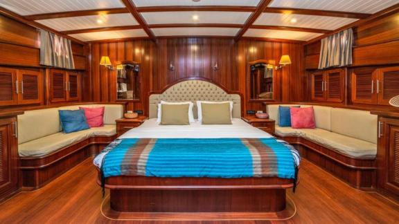 Spacious and luxurious master cabin with double bed and seating areas on the gulet Sema Tuana, equipped with 6 cabins.