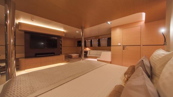 Spacious suite on Omnia with a large bed, TV, and seating area.