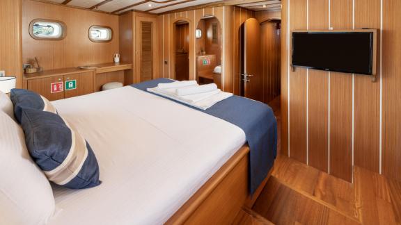 Luxurious cabin on the Gulet Gozdem The One with large bed, wooden furnishings, TV and stylish ambience.