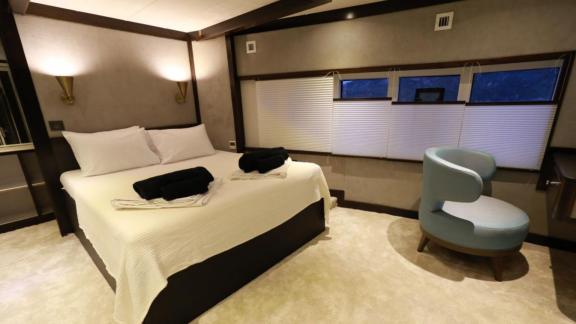 Spacious double bedroom on the trawler Nayk 3, featuring a comfortable seating area.