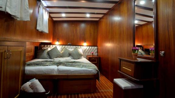 Comfortable guest room of the Gulet Smyrna with elegant wood panelling and a cosy atmosphere.