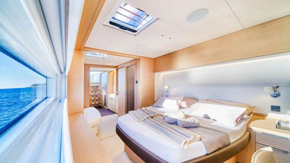 Spacious master cabin with large bed, panoramic window, and en-suite bathroom on the catamaran Amada Mia