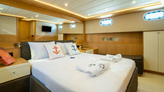 Helle und geräumige Kabine mit stilvollem Interieur und Doppelbett auf der Yacht Ok Ay in Fethiye.