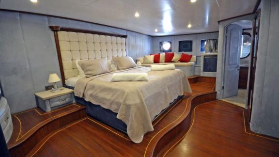 A spacious cabin on the Gulet Bella Mare in Bodrum, with a large bed, elegant wooden floors and stylish decorations.