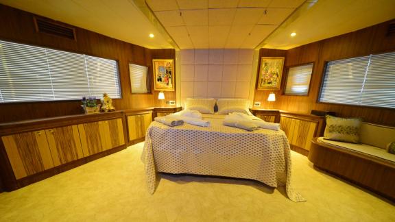 The bedroom of Simay F yacht offers comfort with a large bed and a cozy seating area.