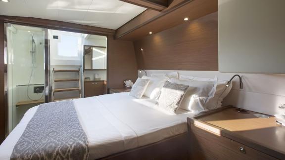 The spacious cabin of the Lagoon 560 in Athens features a cozy double bed and direct access to the modern bathroom.