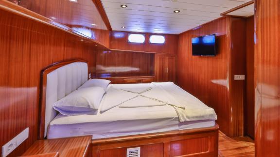 The master cabin on the Gulet Kasapoglu 6 features a comfortable double bed and wood decor.