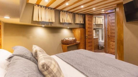 Cozy cabin with a double bed and direct access to an en-suite bathroom on a luxurious yacht.