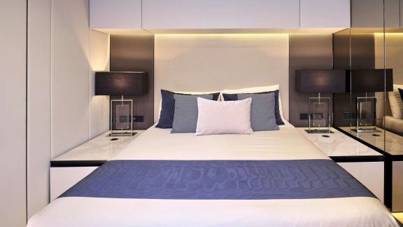 Modern cabin in the Genny catamaran, featuring a stylish double bed and ambient lighting.