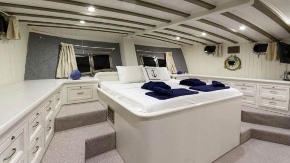 Spacious cabin on The Blue Sea sailing yacht with elegant double bed and plenty of storage space.