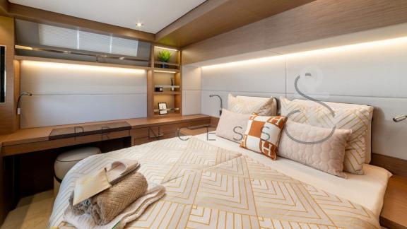 Stylishly furnished cabin with a large bed and desk in the catamaran Princess S