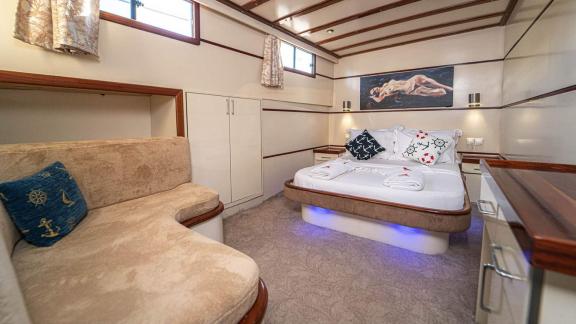 Stylish bedroom with a double bed and cozy seating area on the Gulet Azura.