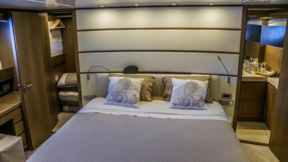 Master cabin of Kuum motor yacht with comfortable bed and modern amenities.