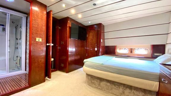 The spacious bedroom on Vedo B yacht offers comfortable accommodation with a modern bathroom and a cozy bed.