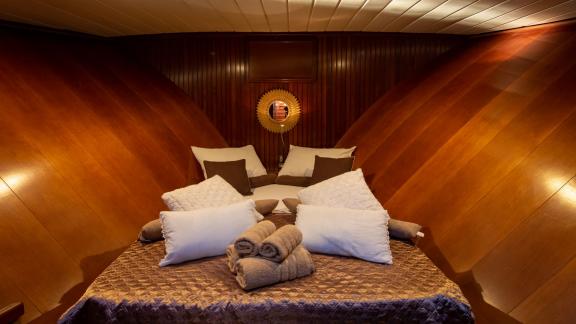 Exclusive sleeping cabin with elegant wooden walls, soft pillows and luxurious bed linen.