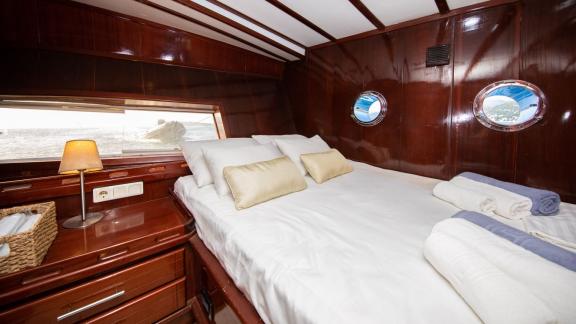 Stylish sleeping cabin on board the Gulet Vivere with a large window.