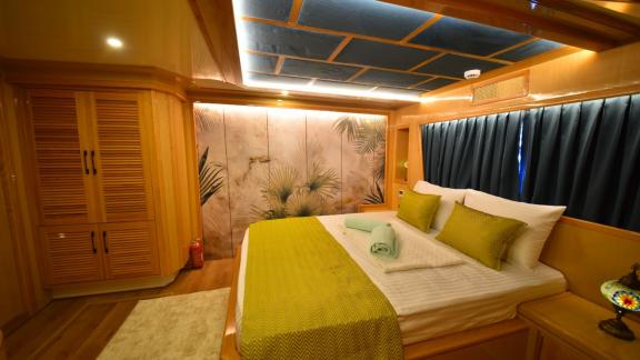 Das elegante Schlafzimmer des Trawlers Compass bietet ein bequemes Bett und stilvolle Dekoration.