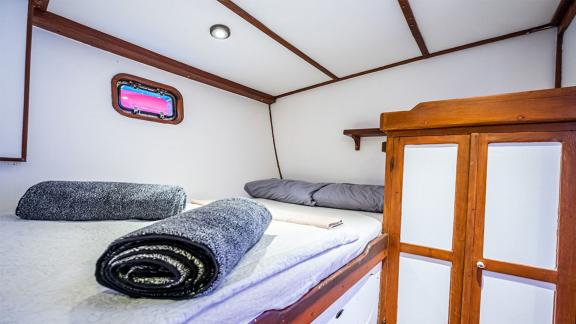 Cozy guest cabin of the 22 meter Gulet Castiel with a comfortable double bed and nautical ambiance.