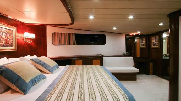 Spacious master cabin with elegant decor and seating area on a yacht in Bodrum.