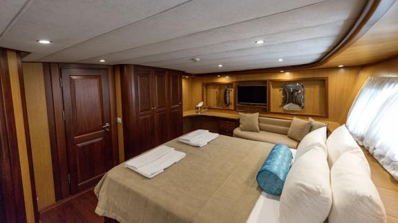 Spacious and elegant cabin with double bed and seating area.