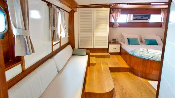 The spacious cabin of Maske 2 features a comfortable bed and a cozy seating area.