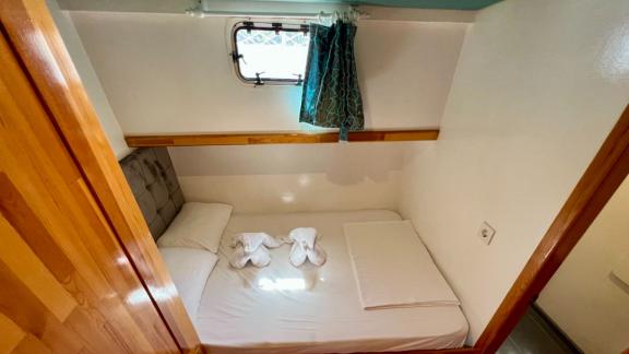 Compact cabin on Gulet Simi with a double bed and a window providing natural light and fresh air.