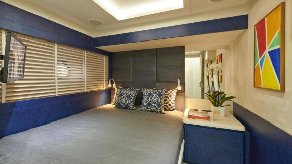 Comfortable guest cabin with stylish blue accents on motor yacht La Fenice.