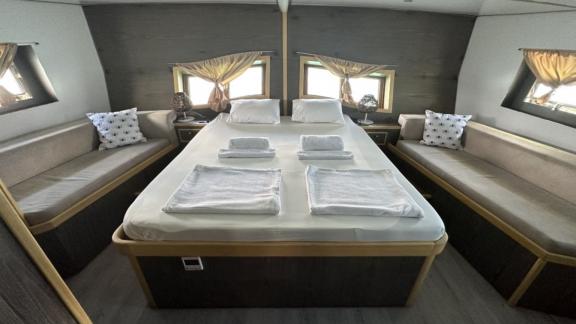 Master cabin with spacious double bed and cozy seating areas on Gulet Aria.