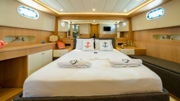 Master cabin of Ok Ay with king-size bed, stylish decor, and daylight windows for a luxurious experience.