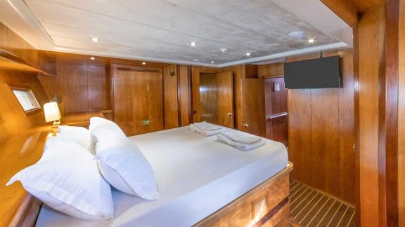 A cosy cabin on a Bodrum gulet with a double bed and wood panelling.