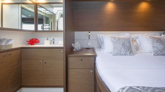 The elegant cabin of the Lagoon 560 in Athens features a comfortable bed and an en-suite bathroom with stylish touches.