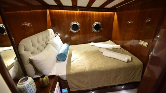 Comfortable double cabin on the Gulet Kayhan 11 in Fethiye with elegant wood interior and plush bedding.