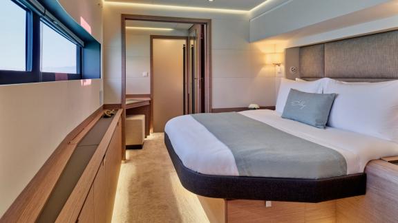 Elegante Kabine der Yacht Elly mit großem Bett, modernem Design und Fenster mit Meerblick.