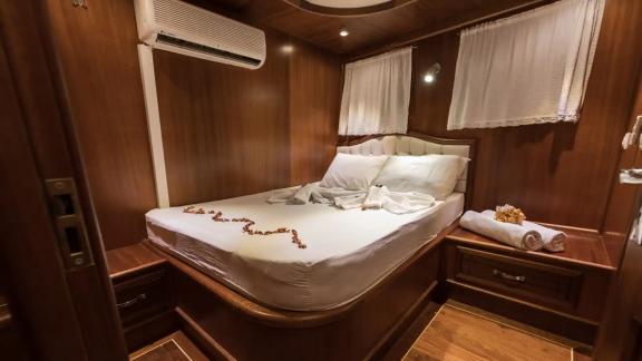 The bedroom on gulet Seven 1 features elegant wood paneling and simple decor.