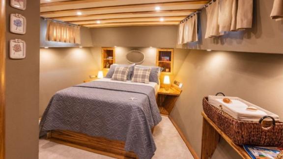 Luxurious cabin on a yacht featuring a stylish double bed, soft lighting, and tasteful decor.