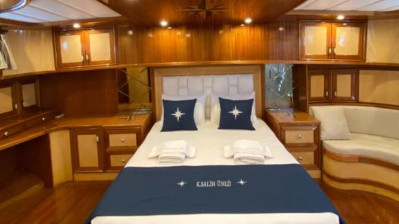 Spacious cabin with double bed, desk, and seating area on Gulet K. Salih Ünlü.