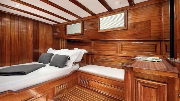 Wood-paneled cabin with a comfortable bed and windows on Serenad A.