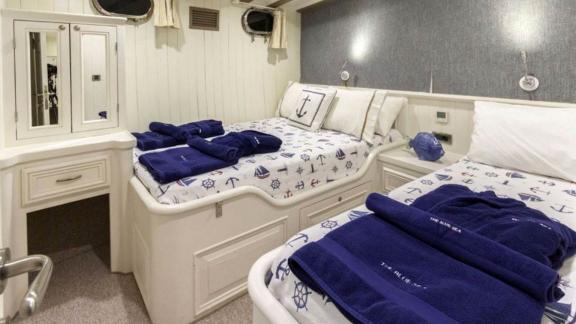 Guest cabin of the sailing yacht The Blue Sea with two single beds.