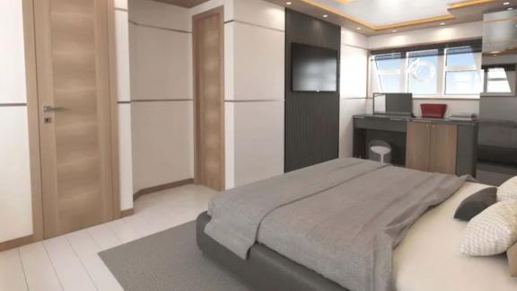 The master cabin of trawler Lavin features a comfortable bed, a work desk, and modern decor.