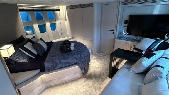 Das Schlafzimmer der Yacht Sfk bietet ein großes Bett, moderne Dekoration und einen bequemen Sitzbereich.