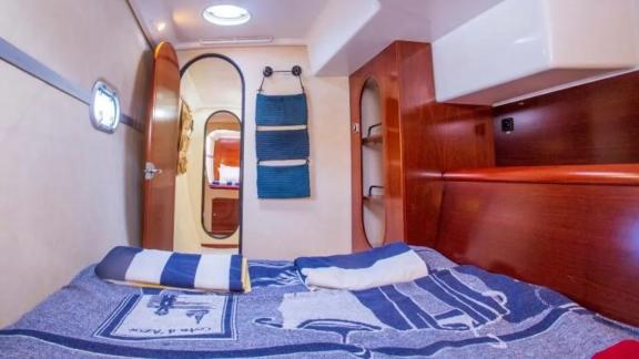 Schlafkabine mit komfortablem Doppelbett und Stauraum auf der Segelyacht Vamos, ideal für Entspannung.