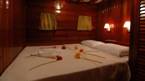 Comfortable cabin on the Sunworld 8 with romantic lighting and decorative flowers.