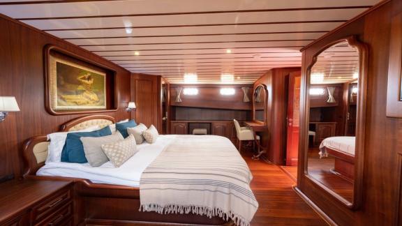 Luxurious master cabin with a large bed and desk, perfect for comfortable relaxation on board the Gulet Bedia Sultan.